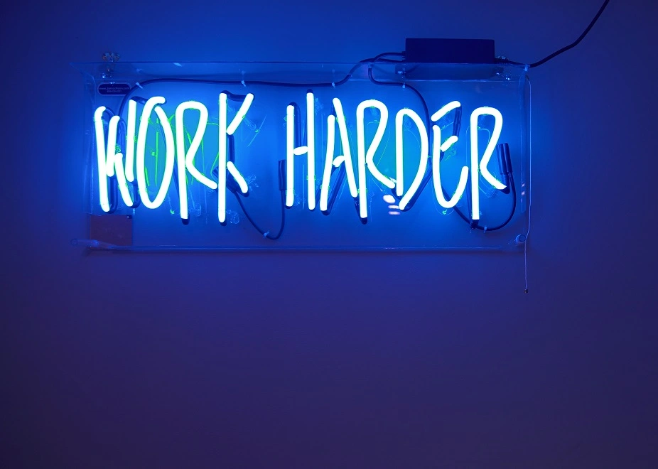 Work Harder Leuchtreklame zeigt Einsatzbereitschaft im Call Center